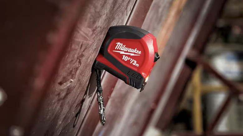 Milwaukee 10 ft. Keychain Tape Measure magnetized to a wall.