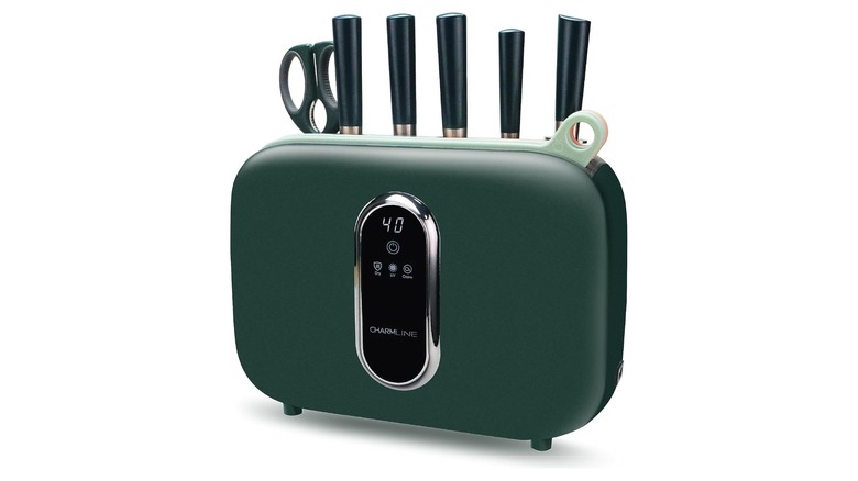 Green rectangular knife block with knive handles sticking out of the top