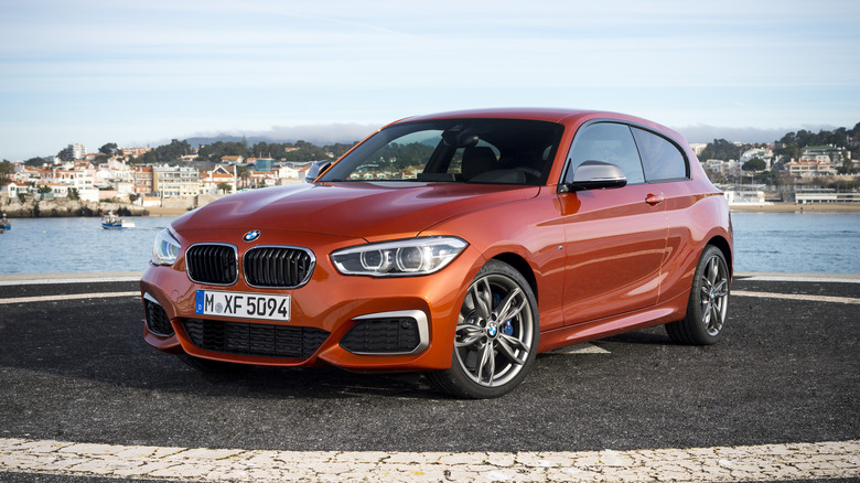 The BMW M135i in orange, front 3/4 view