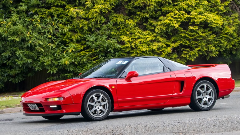 A red NA1 Honda NSX on the move, UK plates, front 3/4 view