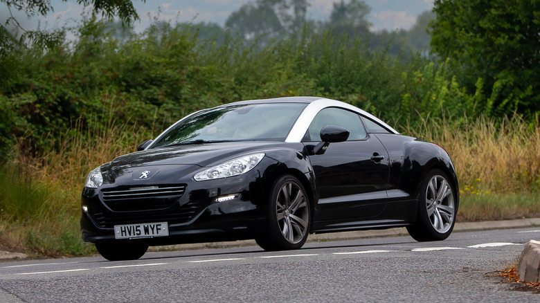 A black facelift Peugeot RCZ on the move, front 3/4 view