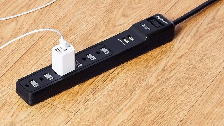 White ipad and power cord plugged into a black power strip