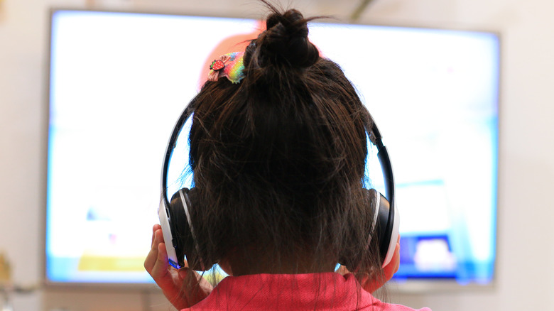 Child looking at screen with headphones on