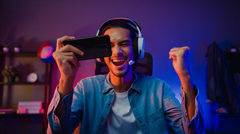 Gamer playing on smartphone with headset