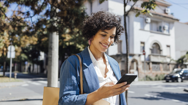 Woman smiling and looking down at phone