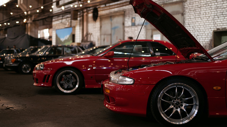 A line of modified cars in a shop