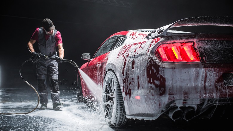 A man cleaning a red sports car