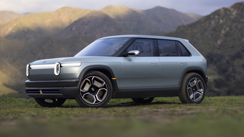 The Rivian R3 on grassy land, front 3/4 view