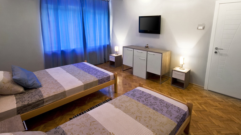 A guest room with two beds facing a tv