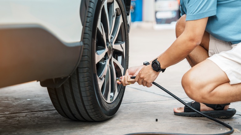 Man inflating car tire