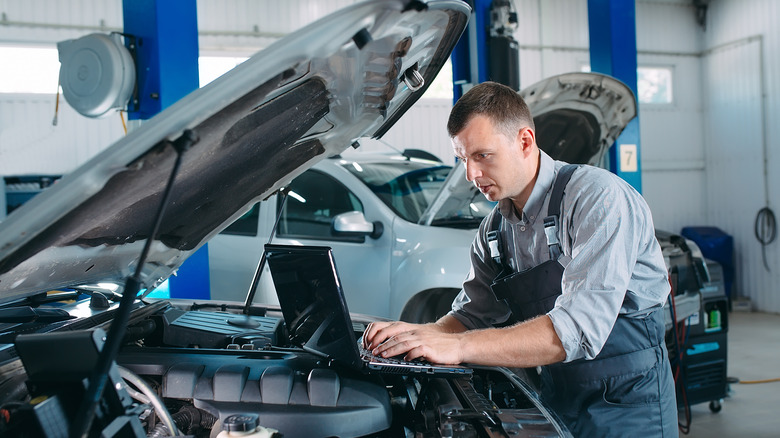 Mechanic inspecting car engine