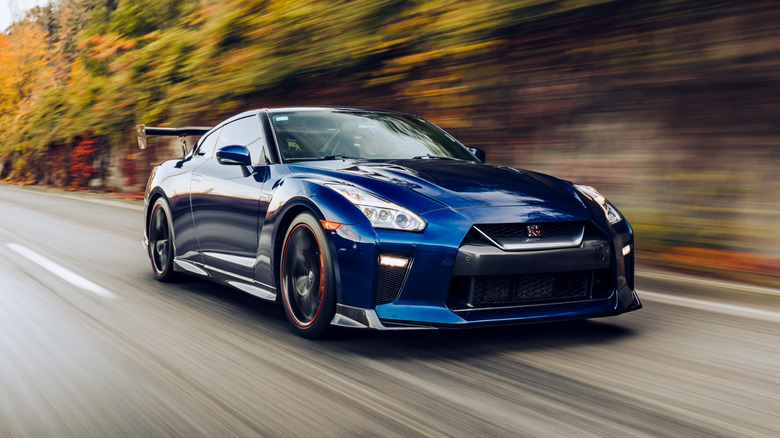 A Nissan GT-R in dark blue on the move, front 3/4 view