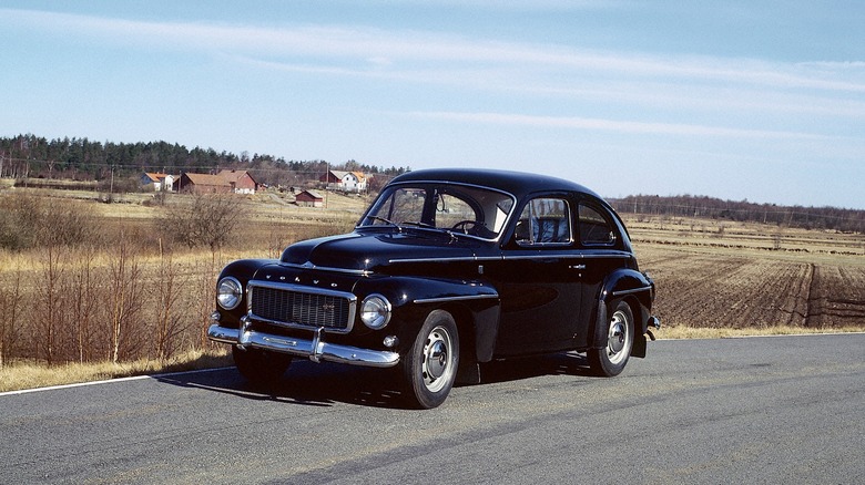 Black 1959 Volvo PV544 parked on a road