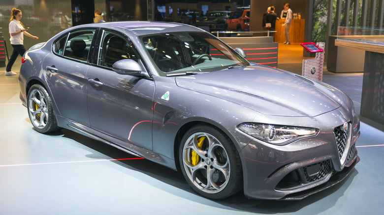 A gray Alfa Romeo Giulia Quadrifoglio at an auto show, front 3/4 view