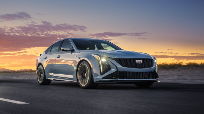 The Cadillac CT5-V Blackwing in bluish gray, front 3/4 view, driving, sunset