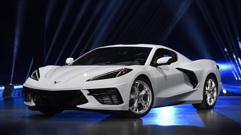 A white C8 Corvette at an auto show, front 3/4 view