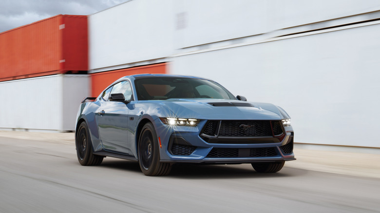 The 2024 Ford Mustang GT in blue on the move, front 3/4 view