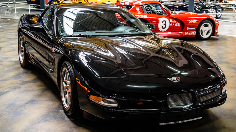 A black Corvette C5 Z06 in a museum, front 3/4 view