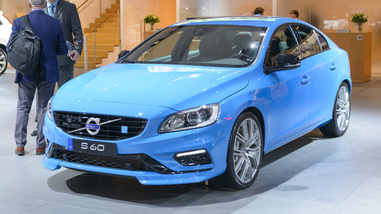 A blue Volvo S60 Polestar at an auto show, front 3/4 view