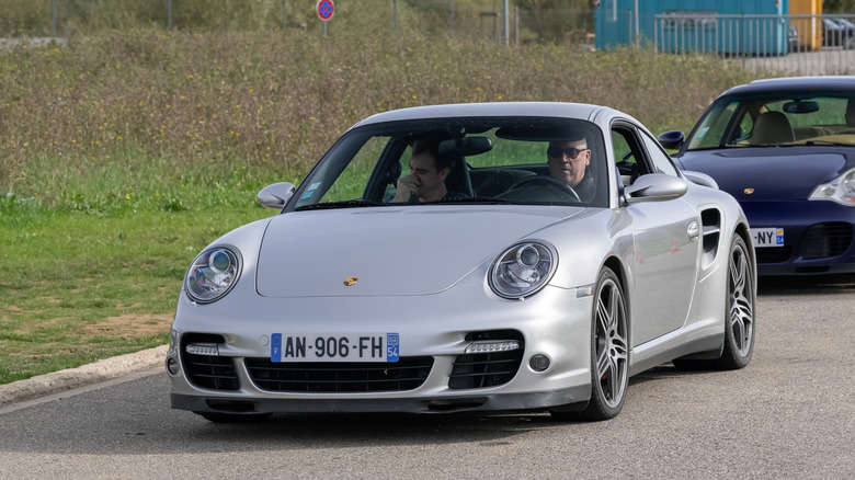 A silver Porsche 997 Turbo on French plates, front 3/4 view