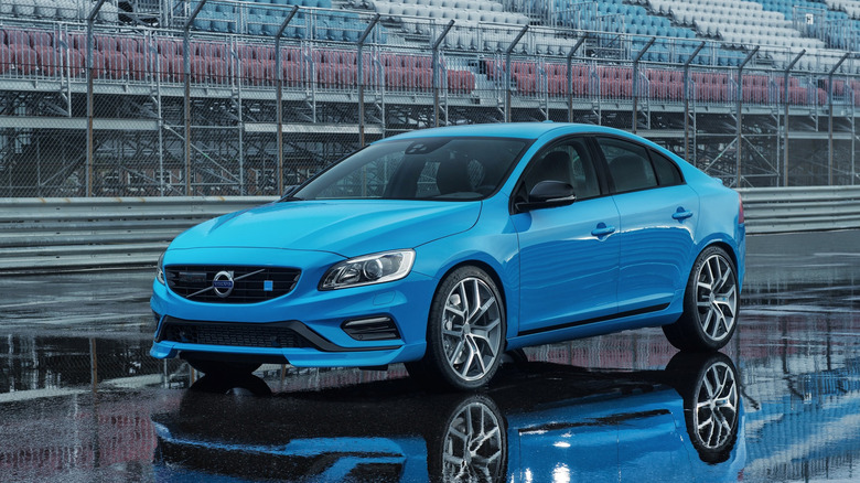 The Volvo S60 Polestar in blue in a wet race track pit lane, front 3/4 view