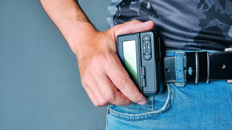 Man clipping pager onto belt