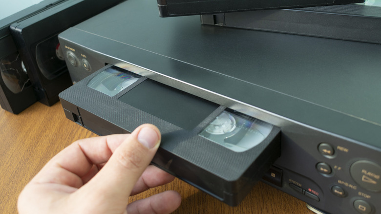 Putting VHS tape into VCR