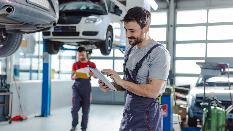 Mechanics servicing car in garage