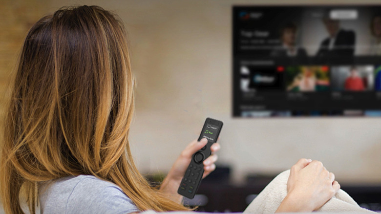 A woman uses the SofaBaton X1S while watching TV.