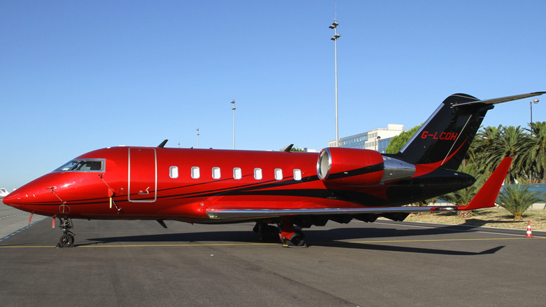 red private jet parked on airstrip