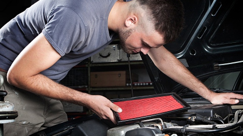 Mechanic replacing engine air filter