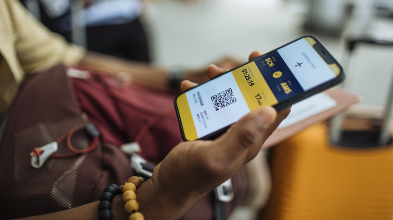 woman holding passport and phone