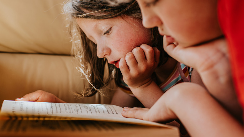 Two kids reading a book