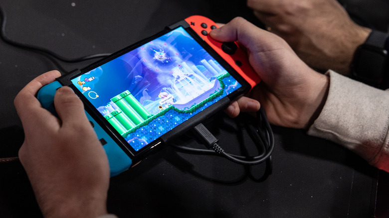 A man playing on a Nintendo Switch OLED.