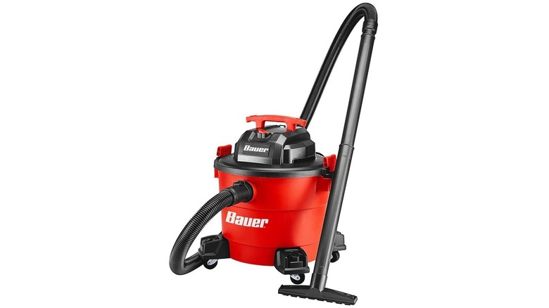 Red canister shop vac on wheels with attached black hose