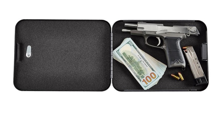 Open black folding safe containing a handgun, stack of hundred dollar bills, and ammunition