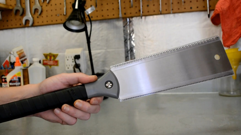 Person holding a Japanese-style saw