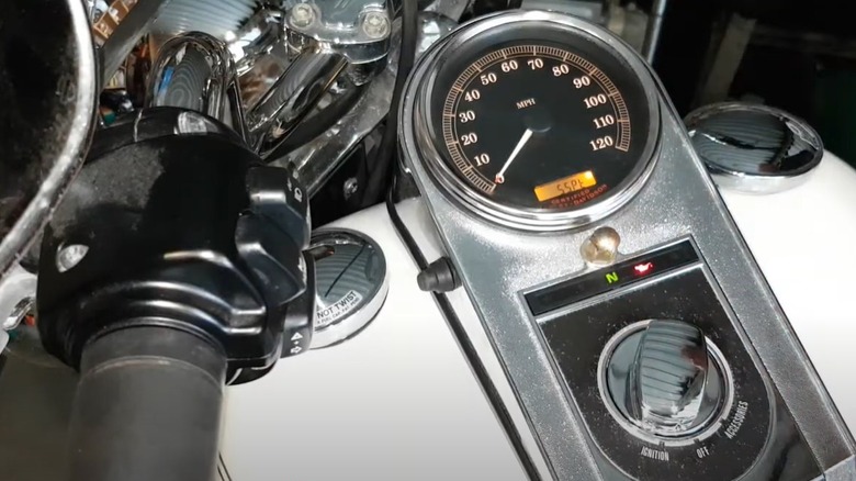 A close view of a motorbike hand knob, a switch and a speedometer