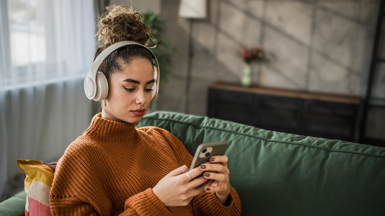 Woman listening to podcast from phone