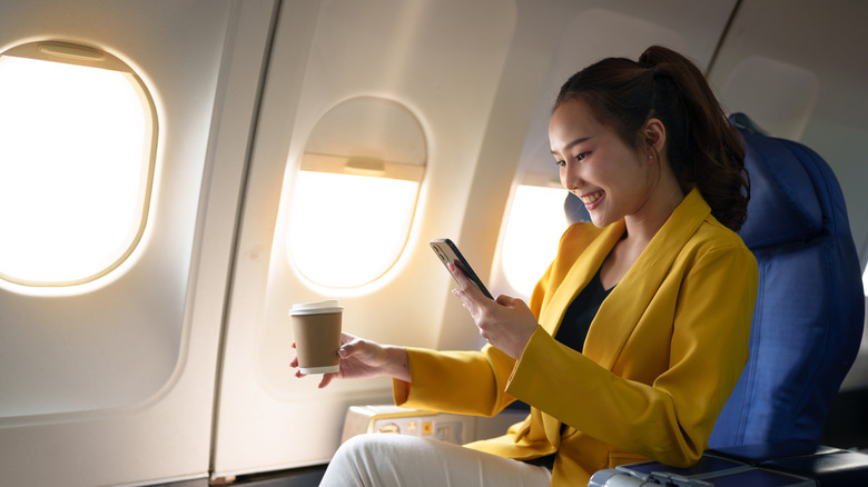 Woman using her smartphone on a flight