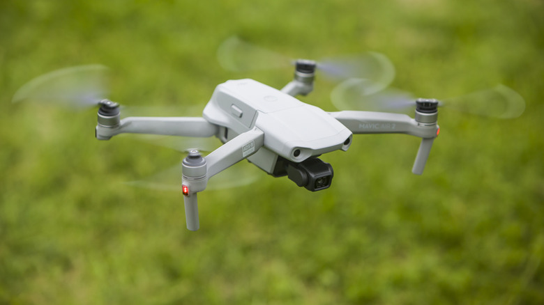 A DJI Mavic 2 flying over grass.