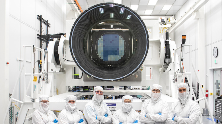 Scientists standing infront LSST camera