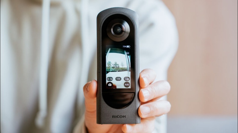 ricoh theta x 360 camera person hand holding