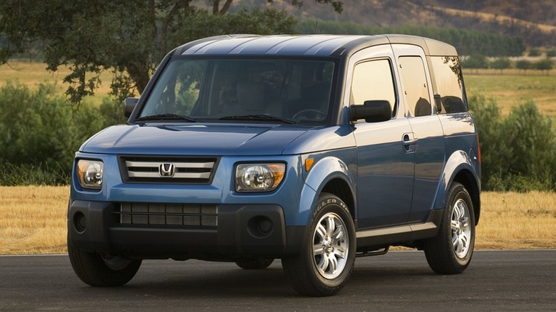 A silver Honda Element parked in an asphalt parking lot