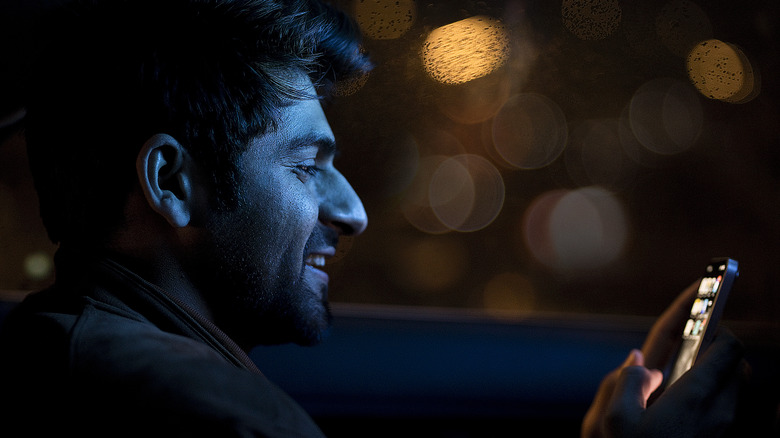 Man staring at phone at night