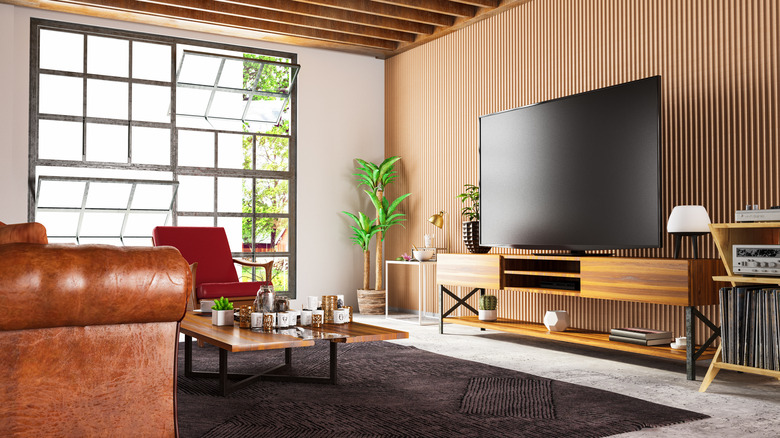 A large TV kept on a wooden table in a living room