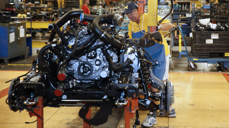 Assembly line worker installs a V6 EcoBoost engine