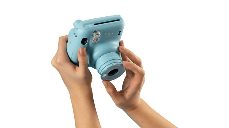 Hands holding Fujifilm camera