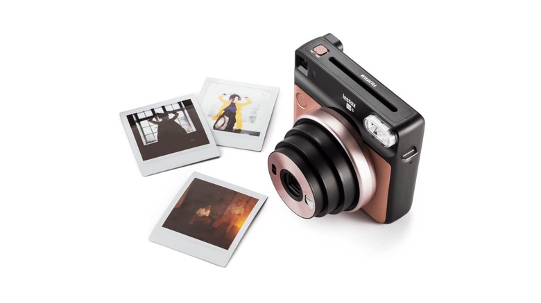 Instant camera next to photos