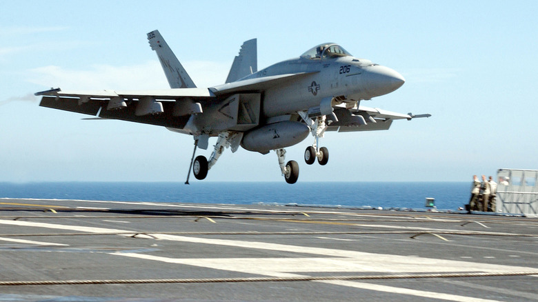 A fighter jet landing on a flight deck